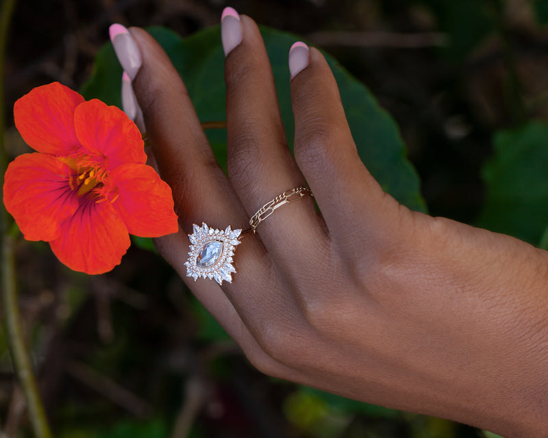 marquise diamond cluster ring on hand holding flower
