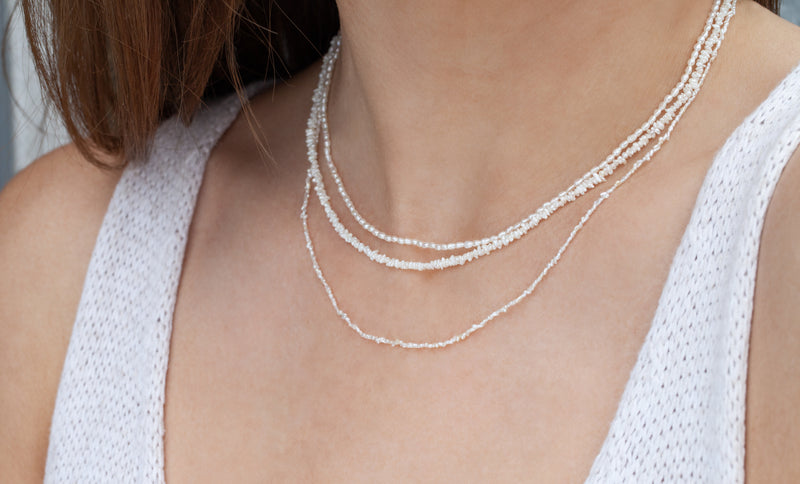 cultured pearl necklace on model wearing multiple necklaces